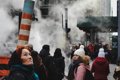 People standing in an inner city while bundled up on a cold day